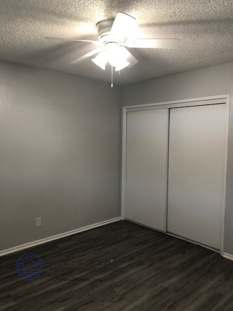 an empty room with a ceiling fan and white doors